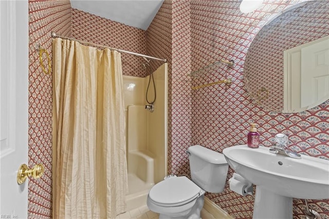 full bathroom featuring toilet and a stall shower