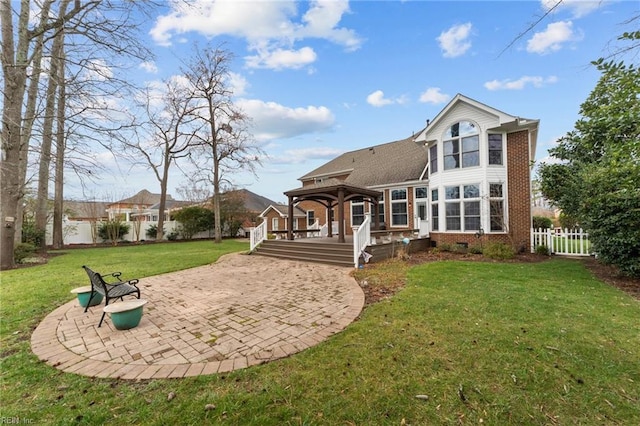 back of house with a deck, a patio, a fenced backyard, crawl space, and a lawn