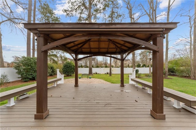 exterior space featuring fence, a wooden deck, a gazebo, and a lawn