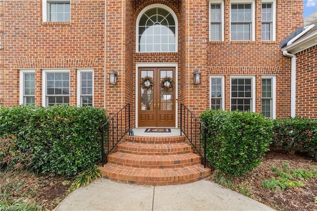 entrance to property featuring french doors and brick siding