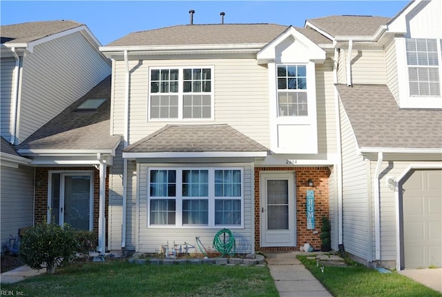 multi unit property with a shingled roof and brick siding