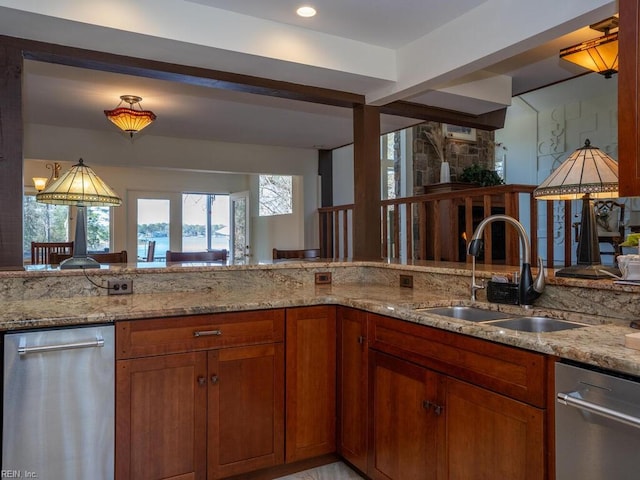 kitchen featuring light stone countertops, dishwasher, brown cabinetry, and a sink