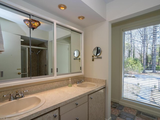 bathroom with a healthy amount of sunlight, a sink, and a shower stall