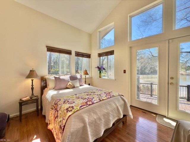 bedroom with access to exterior, visible vents, high vaulted ceiling, baseboards, and hardwood / wood-style flooring