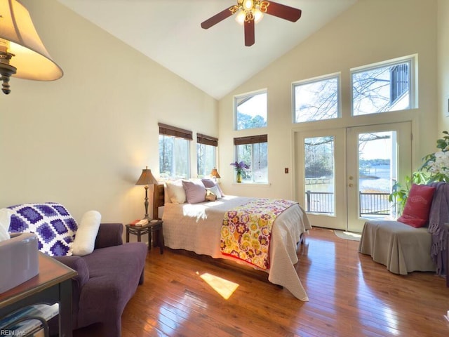 bedroom with access to exterior, wood-type flooring, multiple windows, and french doors