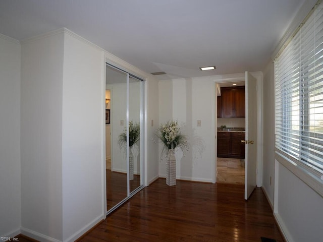 hall featuring baseboards and wood finished floors