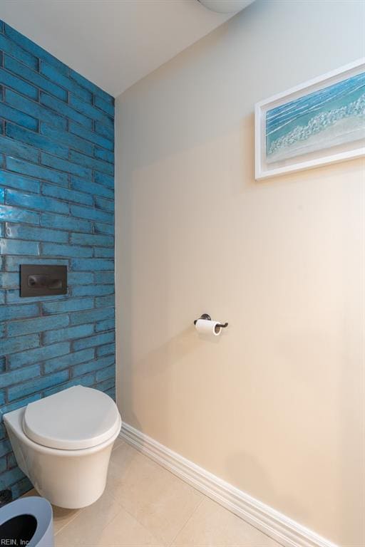 bathroom with toilet, tile patterned flooring, and baseboards