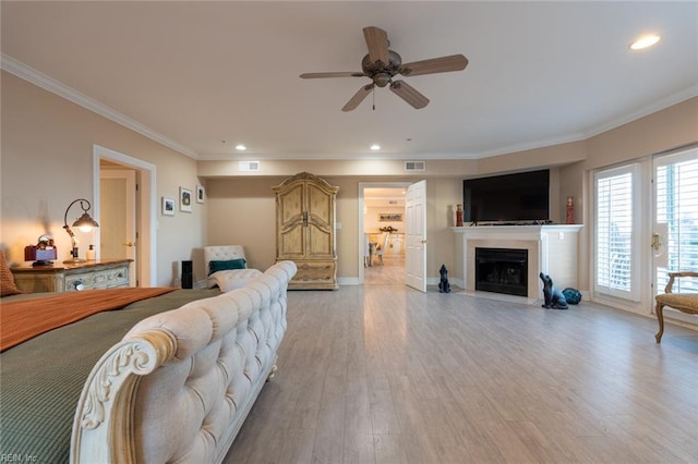 living area featuring visible vents, a fireplace with flush hearth, crown molding, light wood-style floors, and recessed lighting