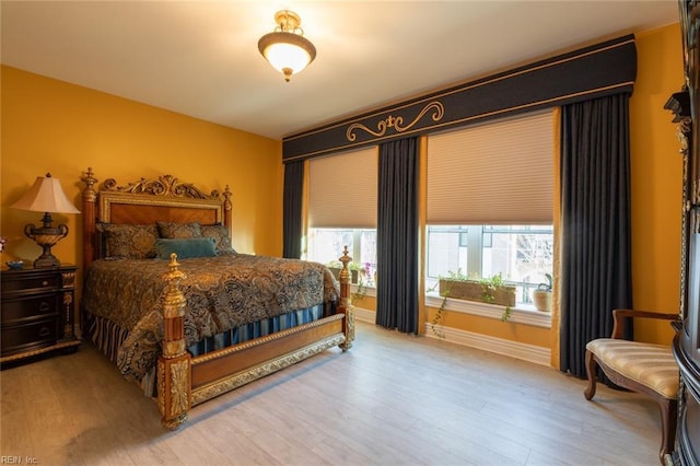 bedroom with baseboards and wood finished floors