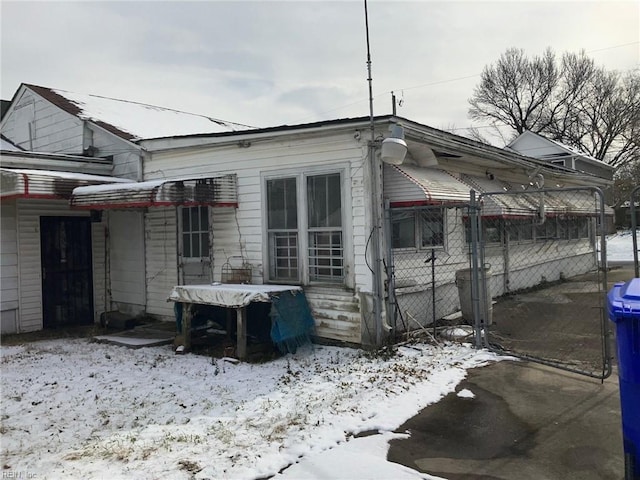 view of snow covered exterior with fence