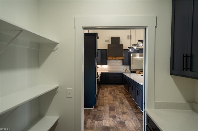 kitchen with tasteful backsplash, light countertops, and dark wood finished floors