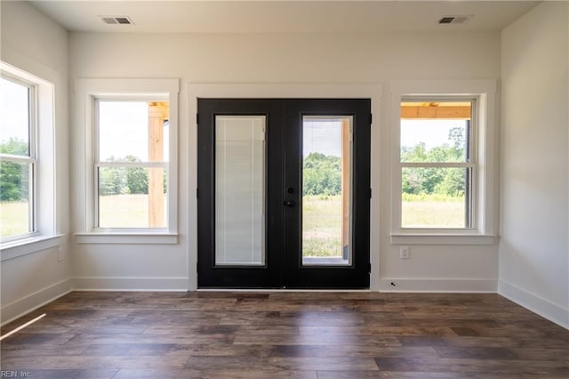 doorway to outside featuring baseboards, french doors, dark wood-style flooring, and a healthy amount of sunlight