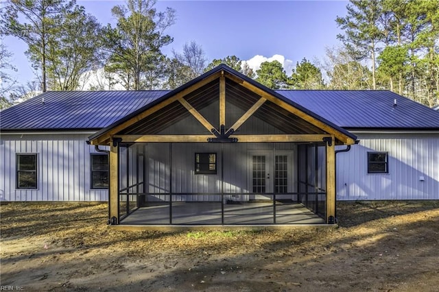 view of front of house featuring a patio area, a standing seam roof, metal roof, and french doors