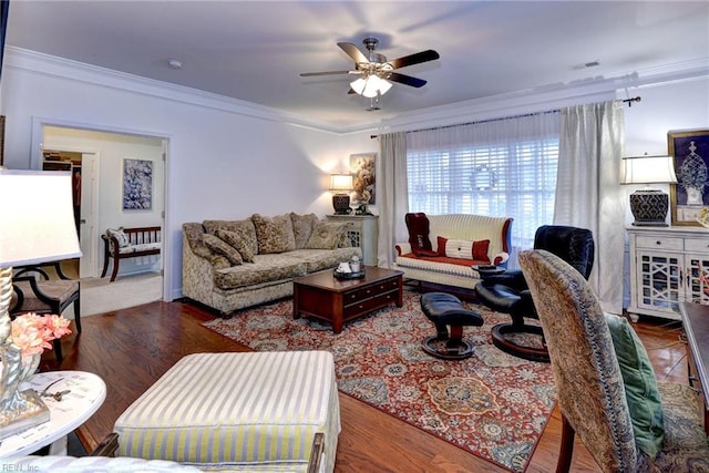 living room with ceiling fan, visible vents, crown molding, and wood finished floors