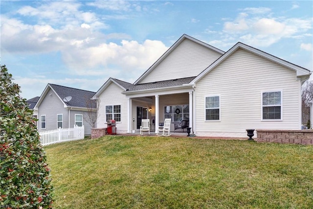 rear view of house with a patio area, a yard, and fence