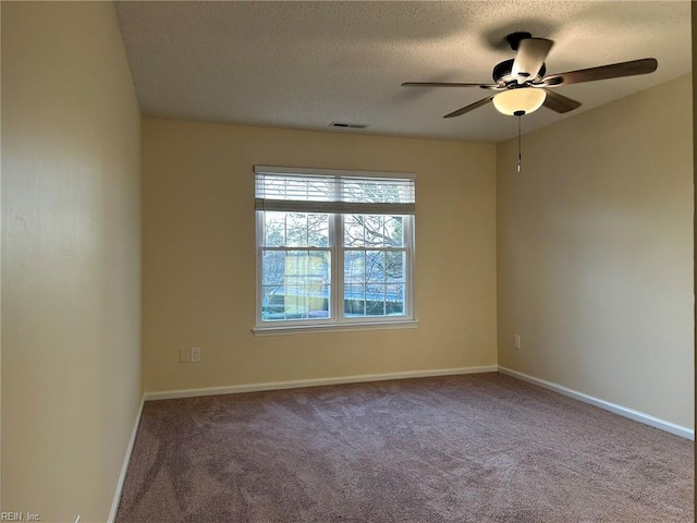 carpeted empty room featuring a textured ceiling, ceiling fan, visible vents, and baseboards