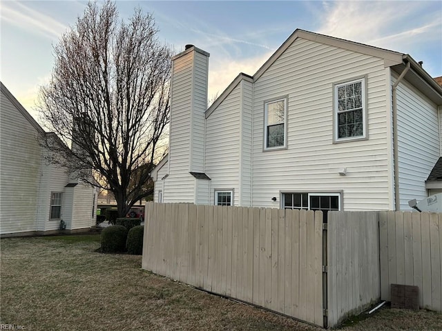 view of home's exterior with a yard and fence