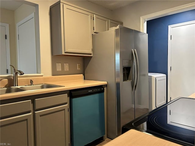 kitchen featuring a sink, light countertops, black electric range oven, dishwasher, and washer / clothes dryer