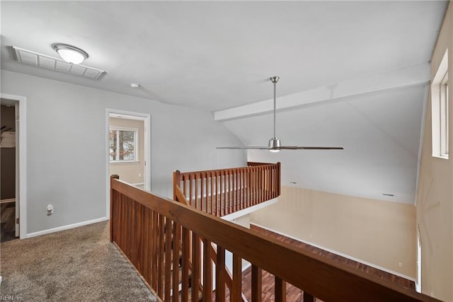 hall featuring carpet, visible vents, baseboards, and an upstairs landing