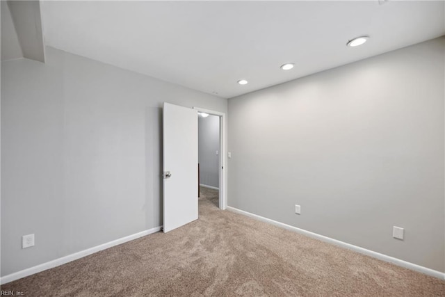 carpeted spare room featuring baseboards and recessed lighting