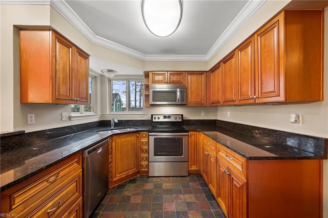 kitchen featuring stainless steel appliances, brown cabinetry, ornamental molding, a sink, and dark stone counters