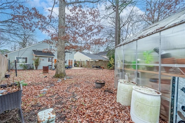 view of yard featuring an outbuilding, a greenhouse, and a fenced backyard