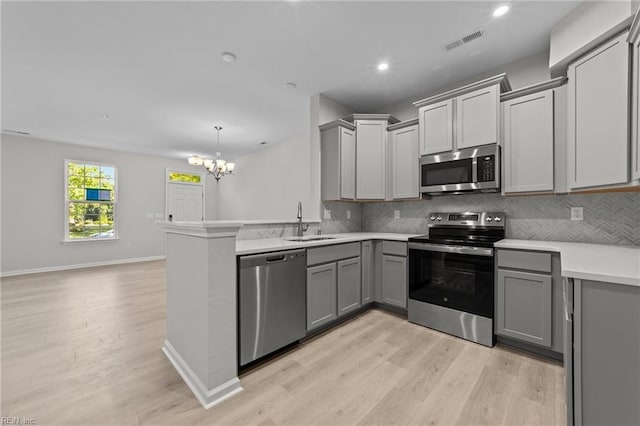 kitchen featuring gray cabinets, visible vents, stainless steel appliances, and a sink