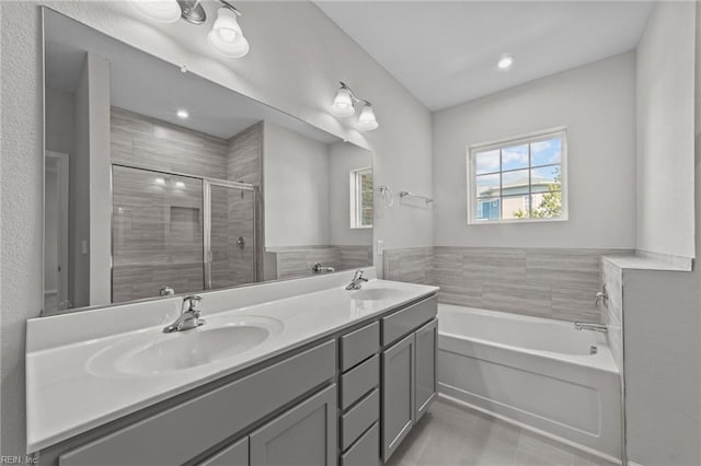 bathroom featuring a garden tub, a sink, a shower stall, and double vanity