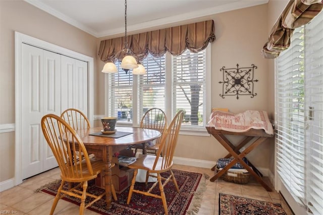 dining space featuring light tile patterned floors, ornamental molding, an inviting chandelier, and baseboards