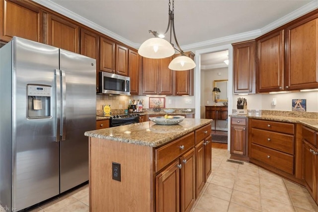 kitchen with brown cabinetry, ornamental molding, a center island, light stone countertops, and stainless steel appliances