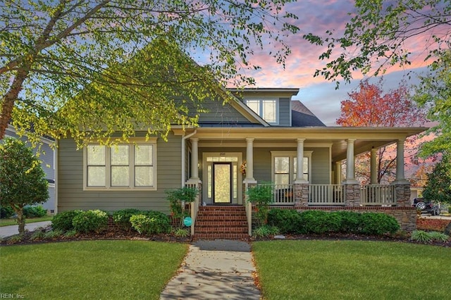 view of front of house featuring covered porch and a lawn