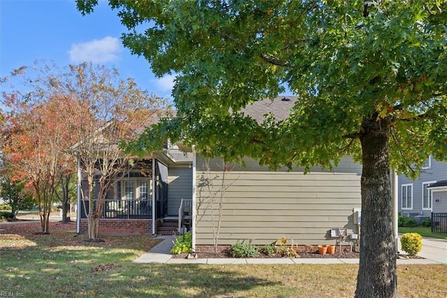 view of property exterior featuring a porch and a yard