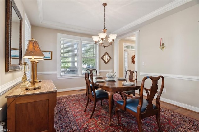 dining area featuring crown molding, baseboards, and wood finished floors