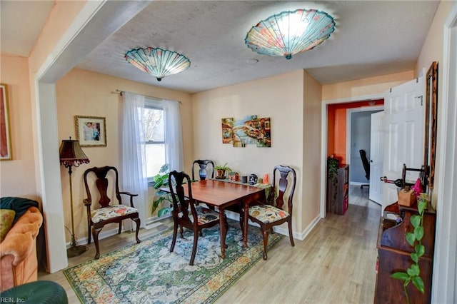 dining room with light wood finished floors and baseboards