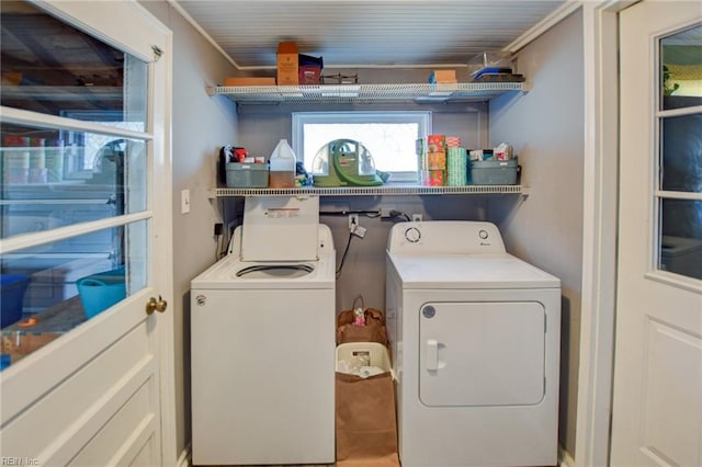 clothes washing area with crown molding, laundry area, and washer and dryer