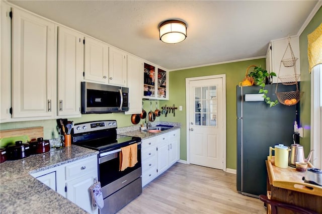 kitchen featuring ornamental molding, appliances with stainless steel finishes, light wood-style floors, and white cabinets