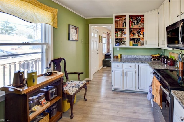 kitchen featuring appliances with stainless steel finishes, ornamental molding, light stone countertops, light wood-type flooring, and white cabinetry