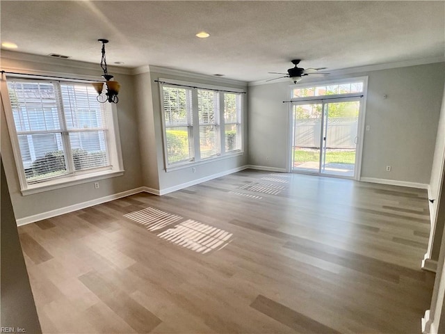 interior space with baseboards, wood finished floors, and crown molding