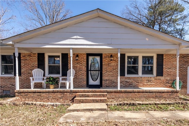 bungalow with crawl space, covered porch, and brick siding