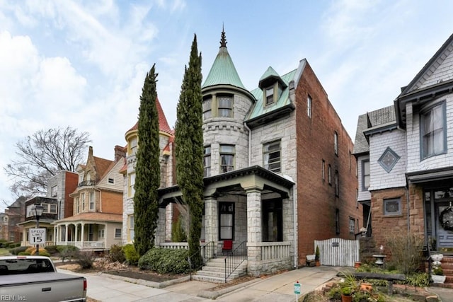 victorian house featuring stone siding and metal roof