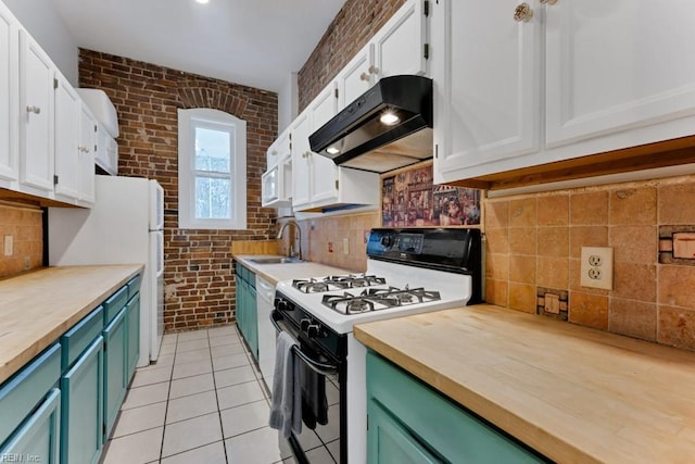 kitchen with under cabinet range hood, brick wall, wood counters, white cabinets, and gas range oven