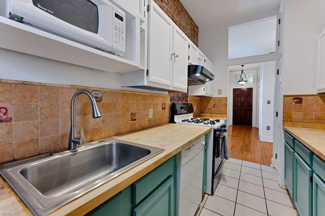 kitchen featuring white appliances, green cabinetry, under cabinet range hood, white cabinetry, and a sink