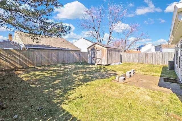 view of yard with a storage shed, central AC unit, an outdoor structure, and a fenced backyard