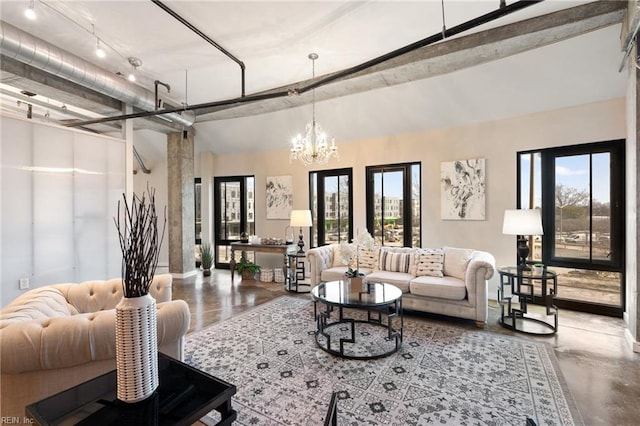 living area featuring a wealth of natural light, a chandelier, and concrete floors