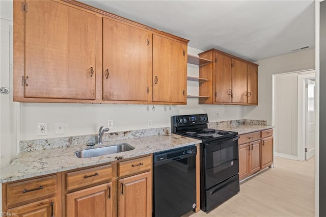 kitchen featuring light stone counters, open shelves, a sink, black appliances, and light wood finished floors