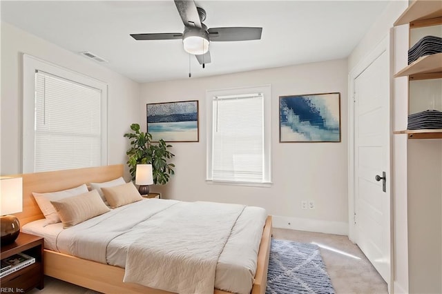 bedroom with light colored carpet, visible vents, ceiling fan, and baseboards