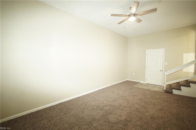 carpeted spare room with a ceiling fan, baseboards, and stairs