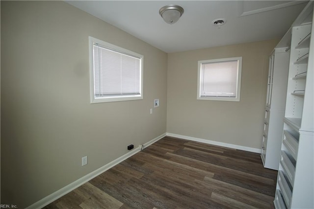 interior space with dark wood-type flooring, visible vents, and baseboards