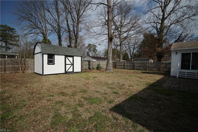 view of yard featuring a fenced backyard, an outdoor structure, and a storage shed