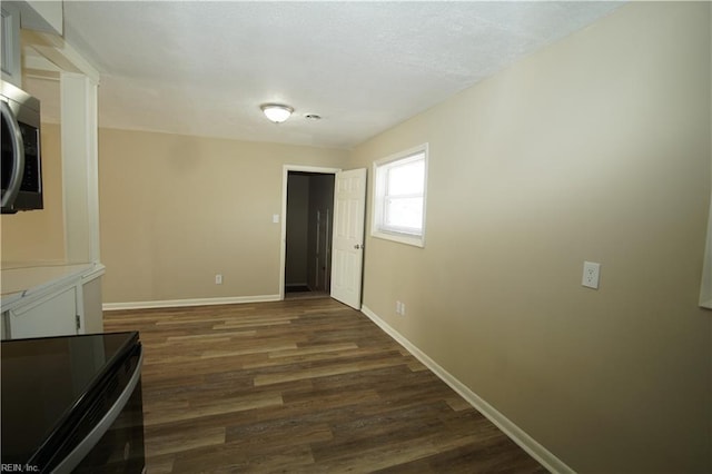 hallway with dark wood finished floors and baseboards